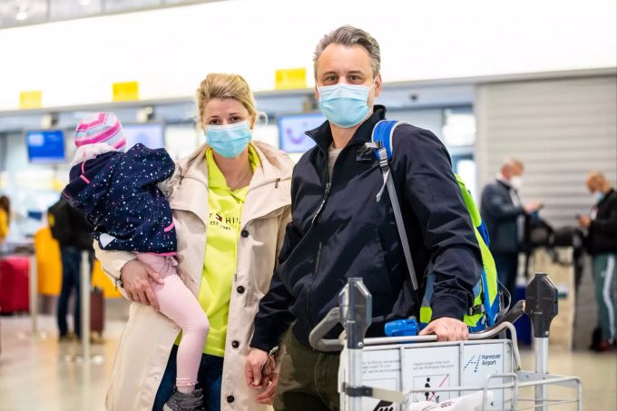 Marlen und Sebastian Wendt, Fluggäste mit dem Reiseziel Mallorca, stehen mit ihrer Tochter im Flughafen Hannover-Langenhagen. Coronavirus - Tourismus