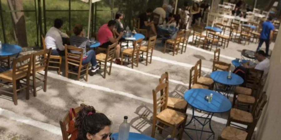 Ein Hauch von Normalität: Café-Besucher in Athen. Foto: Socrates Baltagiannis/dpa