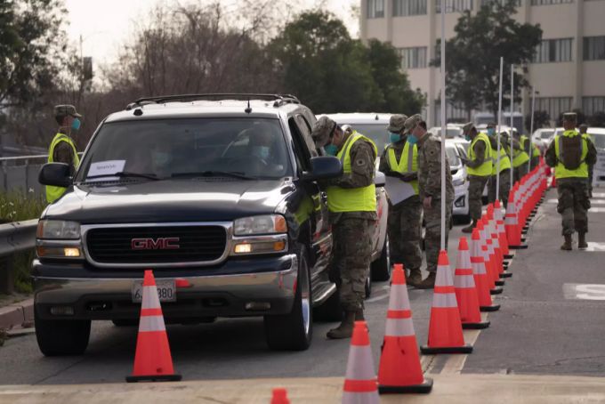 US-Amerikaner stehen in ihren Autos für eine Corona-Impfung Schlange. coronavirus impfung usa