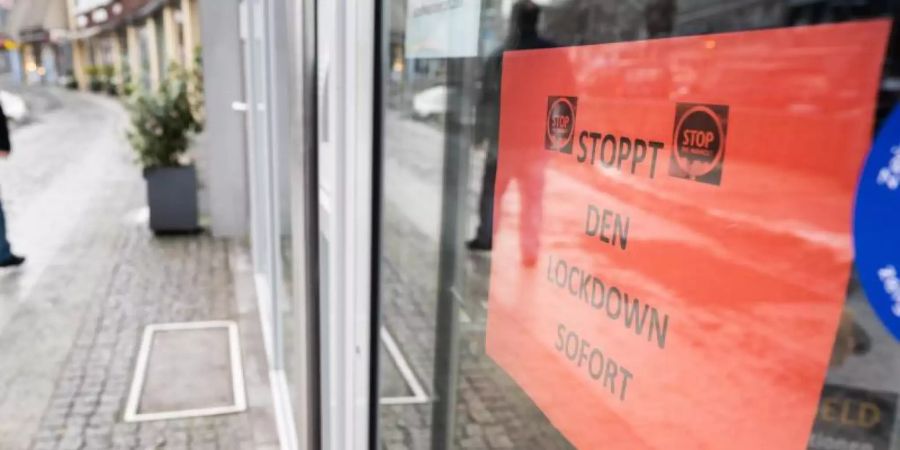 Ein Schild «Stoppt den Lockdown sofort» hängt in der Eingangstür eines Geschäftes in der Innenstadt von Hannover. Foto: Julian Stratenschulte/dpa