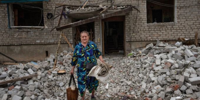 Eine Frau verlässt ihr Haus in Tschassiw Jar mit Habseligkeiten, nachdem eine Rakete den Wohnblock getroffen hat. Mehrere Menschen wurden bei dem Anschlag verletzt und getötet. Ukraine Krieg