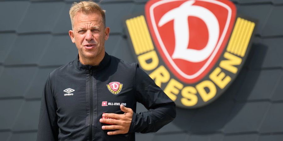 Der neue Trainer des Drittligisten SG Dynamo Dresden, Markus Anfang, steht vor dem Dynamo-Logo.