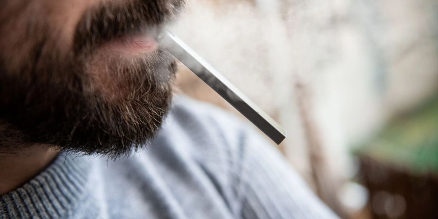 Ein Mann hält eine E-Zigarette im Mund. Wegen anstehender Steuererhöhungen ziehen Hersteller und Händler von E-Zigaretten vor das Bundesverfassungsgericht.