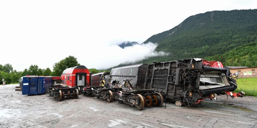 Die zerstörten Zugwagons und die Drehgestelle stehen in der Nähe der Unglücksstelle auf einem Betriebshof.