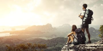 Wanderer mit Rucksack geniessen Talblick.