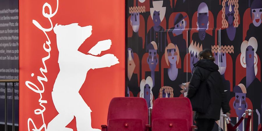 ARCHIV - Eine Frau geht am Logo der Filmfestspiele Berlinale vorbei. Foto: Paul Zinken/dpa