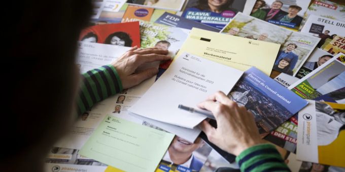 Eine Frau betrachtet das Wahlmaterial für die National- und Ständeratswahlen im Kanton Bern. Wahlen 2023 Flyer