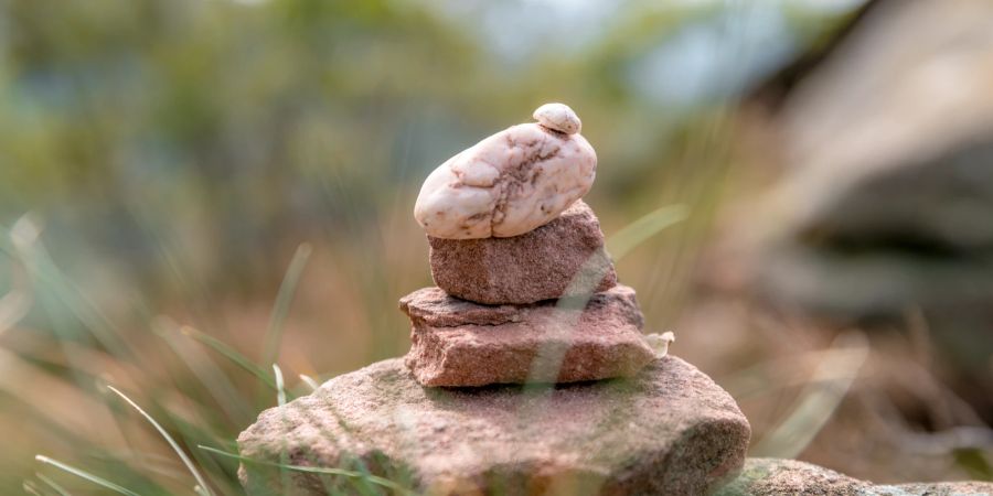 Steine aufeinander geschichtet zu einem kleinen Turm iim Freien.