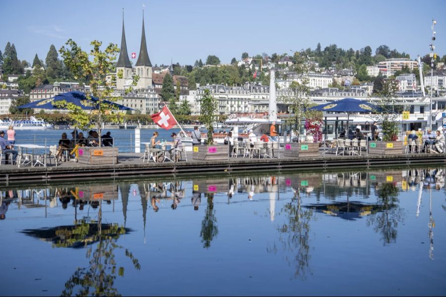 Menschen geniessen die warmen Temperaturen am 16. September 2023 vor dem KKL in Luzern.