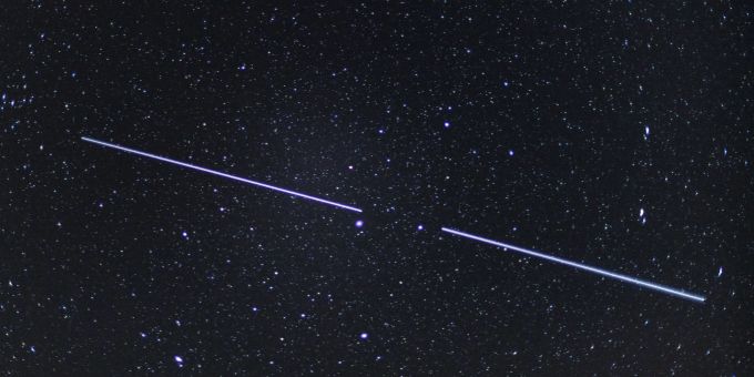 Zwei Starlink-Satelliten sind als Lichtstreifen am Nachthimmel zu sehen. (Archivbild) Starlink