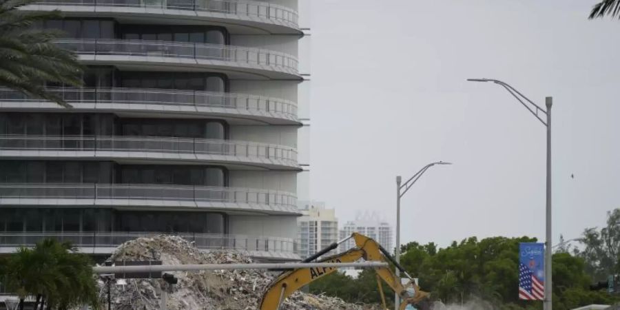 Ein Bagger entfernt Trümmer des eingestürzten Gebäudes im US-Bundesstaat Florida. Gut einen Monat nach dem Unglück haben Einsatzkräfte die sterblichen Überreste der letzten noch vermissten Person identifiziert. Foto: Rebecca Blackwell/AP/dpa