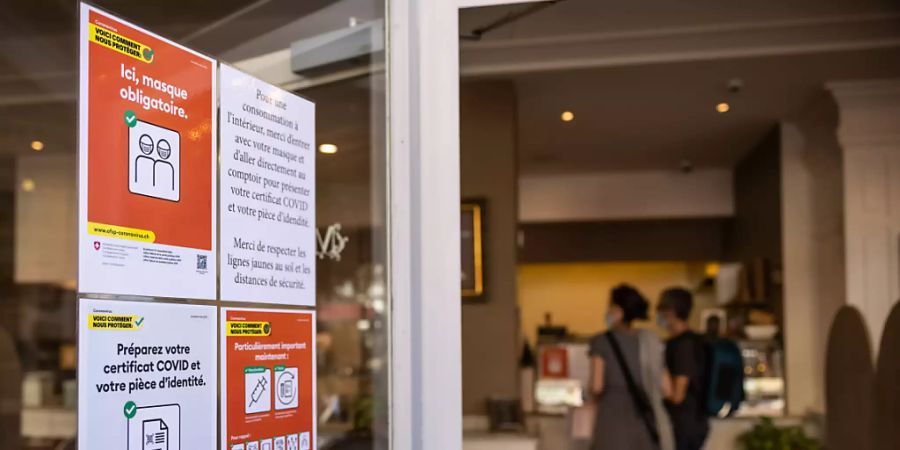 Ein Plakat informiert Gäste eines Restaurants in Genf über die geltenden Massnahmen zur Eindämmung des Coronavirus. (Themenbild)