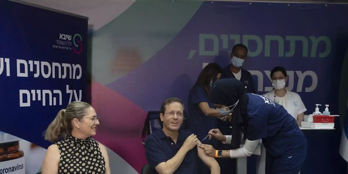 Izchak Herzog (M), Staatspräsident von Israel, erhält eine dritte Impfung gegen das Coronavirus, während seine Frau Michal (l) zusieht. Foto: Maya Alleruzzo/POOL AP/dpa Izchak Herzog Israel coronavirus