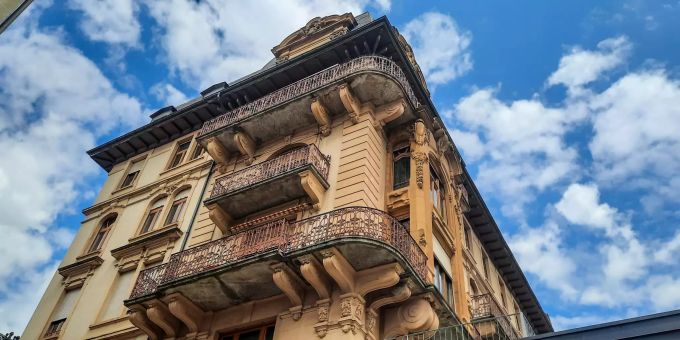 Auch ein Blick zum Himmel lohnt sich bei einem Stadtrundgang durch La Chaux-de-Fonds. Jugendstil, wohin man schaut. Altes Gebäude