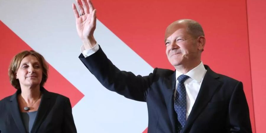 Olaf Scholz, Finanzminister und SPD-Kanzlerkandidat, winkt neben seiner Frau Britta Ernst während der Wahlparty im Willy-Brandt-Haus. Foto: Wolfgang Kumm/dpa