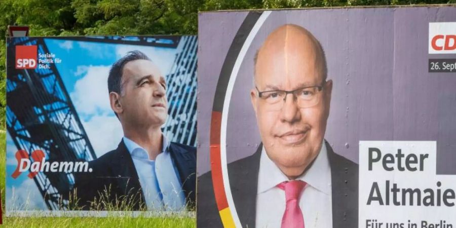 Aussenminister Heiko Maas (SPD, l) hat das Duell gegen Wirtschaftsminister Peter Altmaier (CDU) um das Direktmandat im Wahlkreis Saarlouis gewonnen. Foto: Harald Tittel/dpa