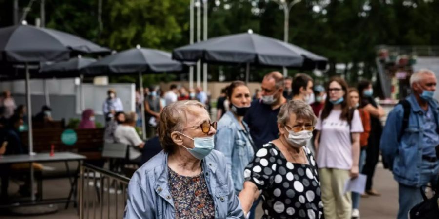 Menschen in Moskau warten vor einem Impfzentrum