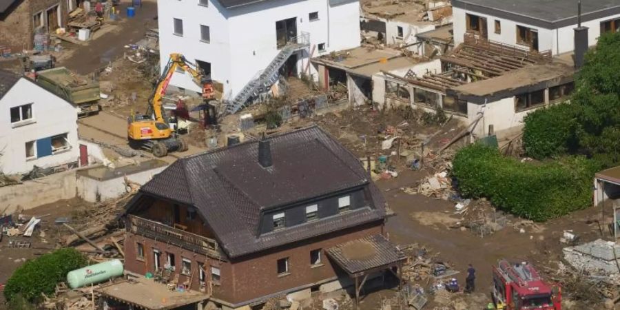 Rettungskräfte sind nach dem Hochwasser im Einsatz. Die Flut hat auch hier zahlreiche Häuser zerstört. Foto: Thomas Frey/dpa