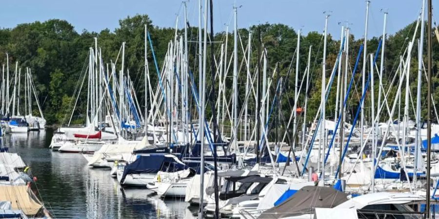 Hunderte Boote liegen im Yachthafen von Ultramarin in Gohren, während ein Mann sein Segelboot aus dem Hafen fährt. Die Nachfrage nach Booten und Hafenplätzen kann aktuell kaum gedeckt werden. Foto: Felix Kästle/dpa