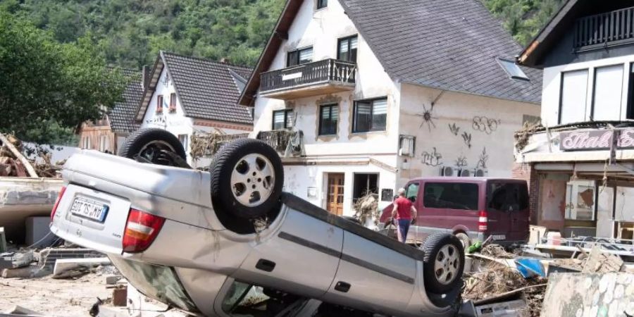 Ein von der Flut mitgerissenes Auto liegt in der Stadtmitte von Altenahr. Zahlreiche Häuser in dem Ort wurden komplett zerstört oder stark beschädigt. Foto: Boris Roessler/dpa