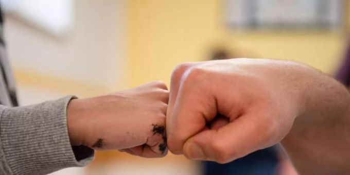 Ein Insasse gibt in der Vater-Kind-Gruppe in der deutschen JVA Nürnberg seinem Sohn einen Fist Bump. Foto: Nicolas Armer/dpa gefängnis