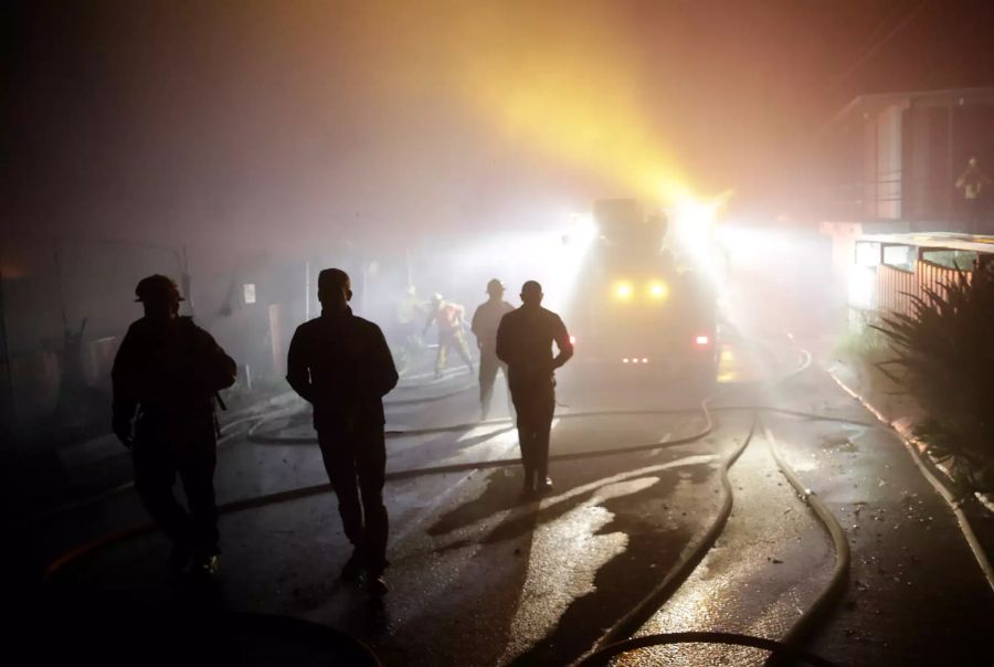 Eric Garcetti (2.v.l), Bürgermeister von Los Angeles, geht neben Einsatzatzkräften der Feuerwehr durch ein Wohngebiet.