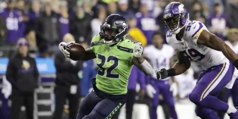 Chris Carson (l) von den Seattle Seahawks enteilt Danielle Hunter von den Minnesota Vikings. Foto: Ted S. Warren/AP/dpa