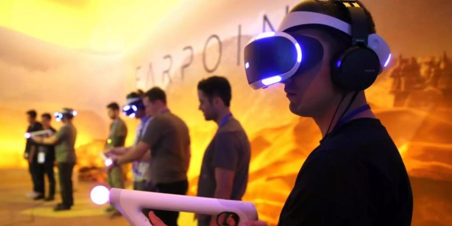 Besucher spielen Farpoint mit der Sony PlayStation VR auf der Electronic Entertainment Expo (E3) in Los Angeles. Foto: Mike Nelson/epa/dpa