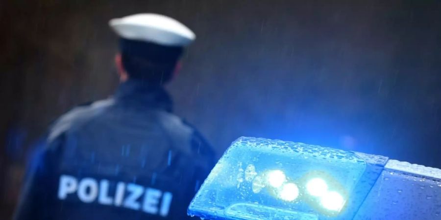 Polizist an einem Streifenwagen