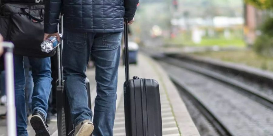 Zugreisende laufen am Bahnsteig am Hauptbahnhof. Hinter der weissen Linie kann es durch einfahrende Züge zu Luftverwirbelungen kommen, die Gegenstände und Personen zum Zug ziehen können. F. Foto: Patrick Seeger/dpa