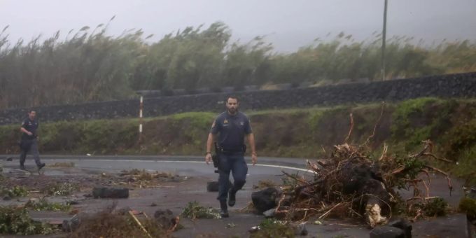 Portugiesische Küstenwache Offiziere gehen zwischen Trümmern, die eine Strasse im Dorf Feteira, auf der portugiesischen Insel Faial, blockieren. Hurrikan