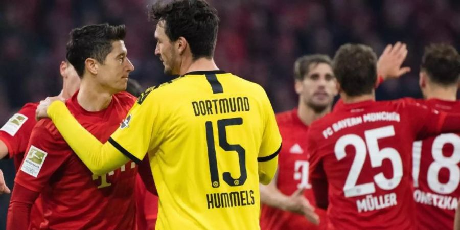 Nach der Niederlage wechselt BVB-Ersatzkapitän Mats Hummels (15) einige Worte mit Bayern-Torjäger Robert Lewandowski (r). Foto: Matthias Balk/dpa