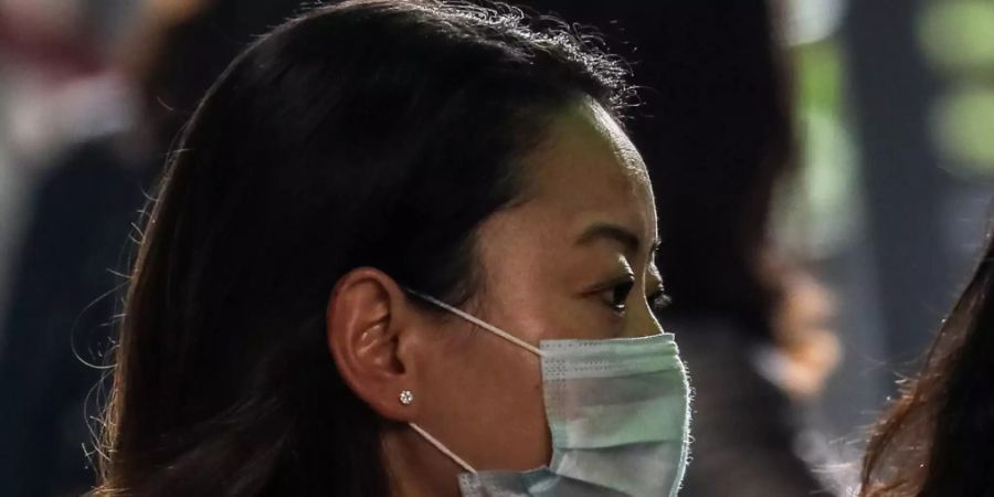 Eine Person schützt sich mit einer Gesichtsmaske vor einer möglichen Ansteckung mit dem Coronavirus. (Symbolbild)