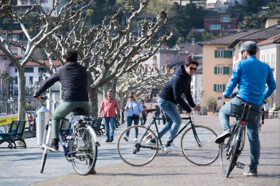 Leute geniessen das schone Wetter an der Uferpromenade von Ascona. (Archivbild)