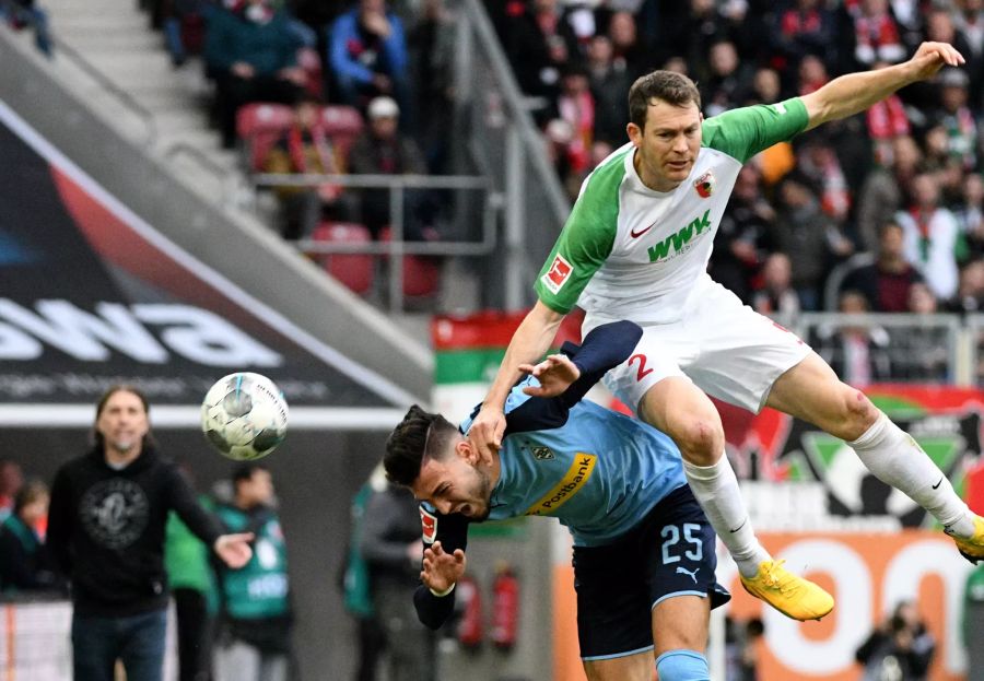 Stephan Lichtsteiner (FC Augsburg) foult Ramy Bensebaini (Borussia Mönchengladbach) im Luftkampf.