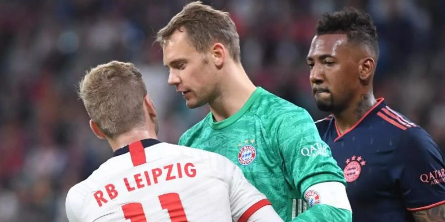 Leipzigs Timo Werner (l) im Gespräch mit Bayerns Torwart Manuel Neuer (M) und Jerome Boateng (r). Foto: Hendrik Schmidt/dpa-Zentralbild/dpa
