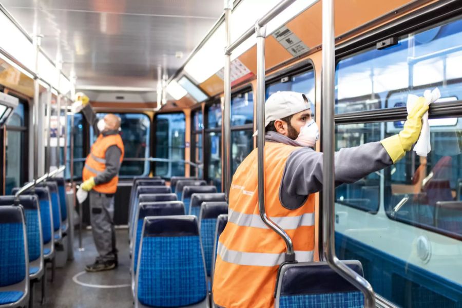 Reinigungs-Fachkräfte desinfizieren ein Tram in Zürich wegen des Coronavirus.