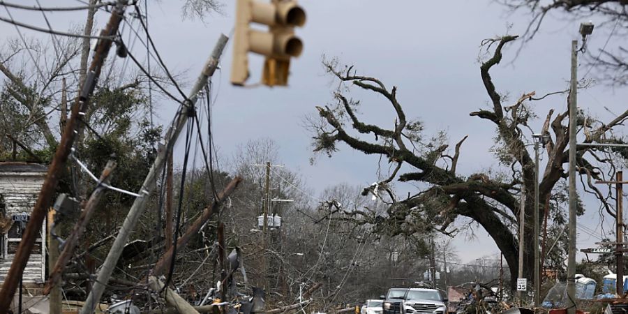 dpatopbilder - Autos fahren vorsichtig an umgestürzten Bäumen und Stromleitungen vorbei. Tornados und schwere Stürme haben im Südosten der USA mindestens sieben Menschen das Leben gekostet. Foto: Stew Milne/AP/dpa