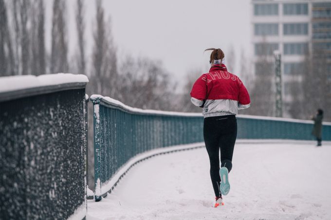 Warm eingepackt, aber bitte nicht zu warm: Wer im Winter beim Laufen zu viel schwitzt, dem wird danach ordentlich kalt. Frau Brücke Schnee Laufen