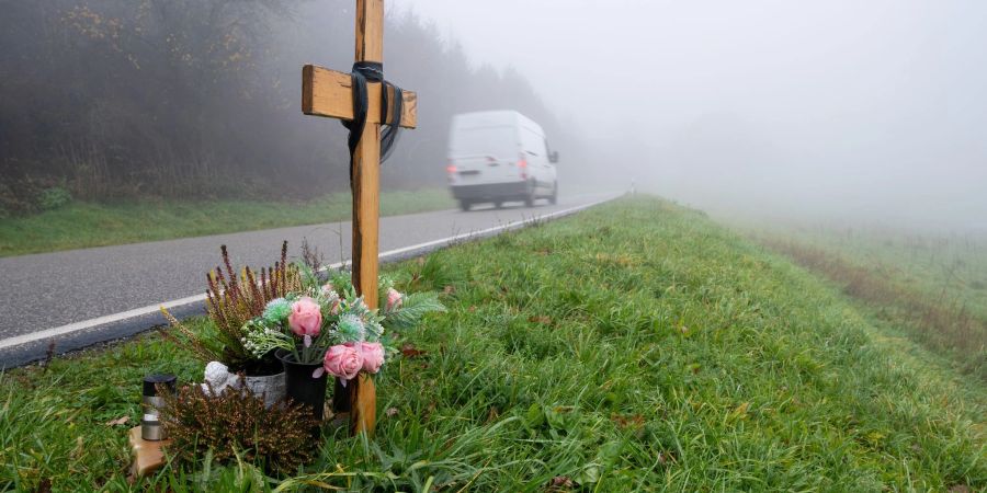 Ein Holzkreuz zum Gedenken wurde am Tatort an der K22 bei Kusel aufgestellt, wo Ende Januar 2022 zwei Polizisten im Dienst getötet wurden.