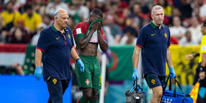 Portugals Nuno Mendes (M) wird verletzt vom Platz geleitet. Verletzt