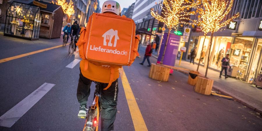 Ein Kurierfahrer des Restaurantlieferdiensts Lieferando fährt mit seinem Fahrrad über die Friedrichstrasse in Mitte in Berlin.