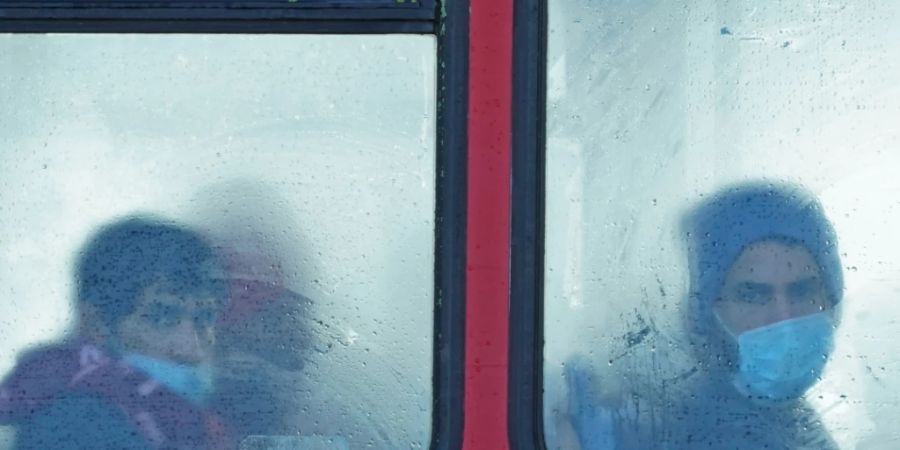 ARCHIV - Eine Gruppe von Menschen, bei denen es sich vermutlich um Migranten handelt, sitzt in einem Bus. Am 24.11.2021 starben mindestens 27 Migranten auf dem Weg nach Grossbritannien, als ihr Boot im Ärmelkanal sank. Foto: Gareth Fuller/PA Wire/dpa