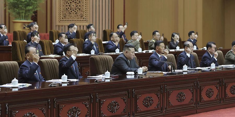 Der Machthaber Nordkoreas Kim Jong Un sitzt im Zentrum einer Sitzung der Regierung von Ende September. Unabhängigen Medienschaffenden wurde kein Zugang zur Sitzung gewährt. Die Regierung stellte das Bild, inklusive Wasserzeichen, zur Verfügung. (Archivbild)