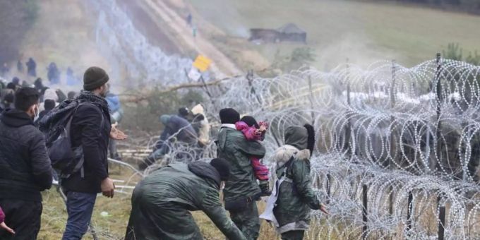 Getrennt durch Stacheldraht: Migranten stehen an der Grenze auf der belarussischen Seite - auf der polnischen stehen Sicherheitskräfte. Foto: Leonid Shcheglov/BelTA/AP/dpa Getrennt durch Stacheldraht: Migranten stehen an der Grenze auf der belarussischen Seite - auf der polnischen stehen Sicherheitskräfte. Foto: Leonid Shcheglov/BelTA/AP/dpa