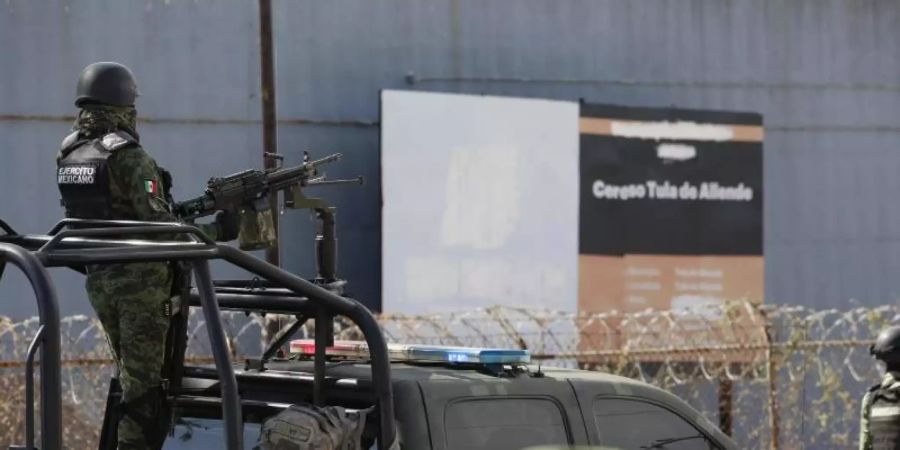 Soldaten der mexikanischen Armee stehen vor einem Gefängnis Wache, nachdem eine Bande mehrere Fahrzeuge in das Gefängnis gerammt hat und mit neun Insassen geflohen ist. Foto: Ginnette Riquelme/AP/dpa