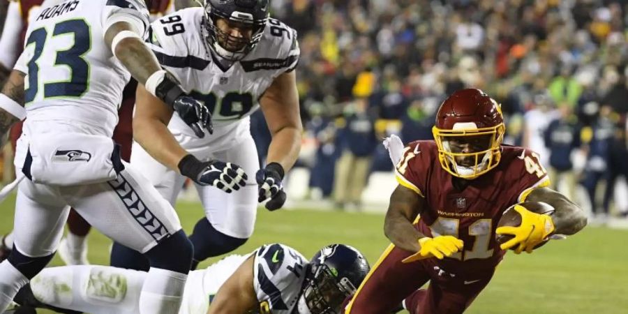 J.D. McKissic (r) setzte sich mit Washington gegen die Seattle Seahawks durch. Foto: Nick Wass/AP/dpa