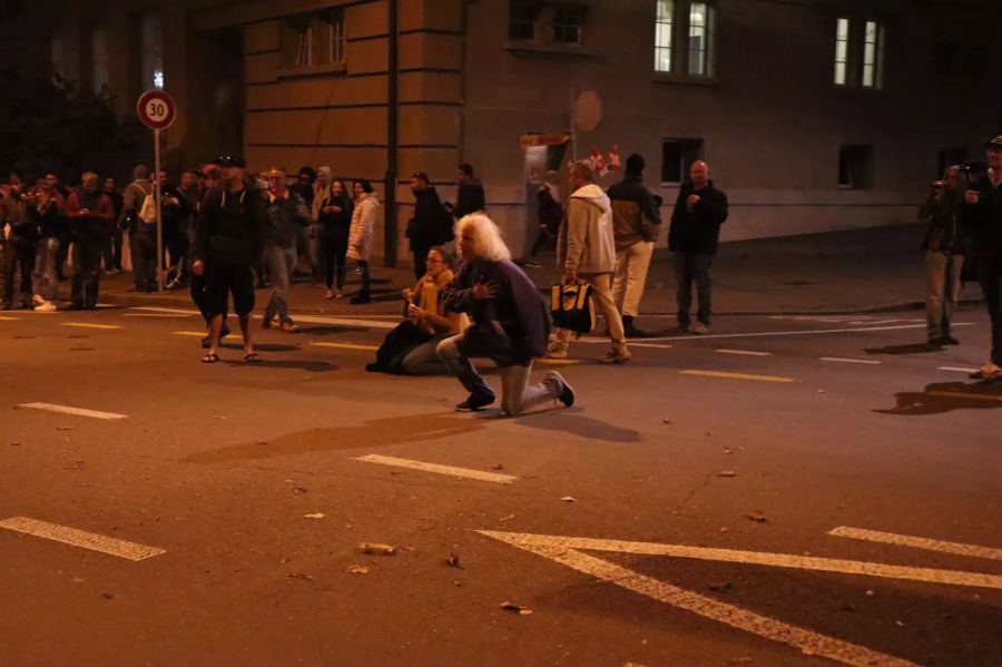 Einige Corona-Demonstranten schauen in Richtung Polizisten.