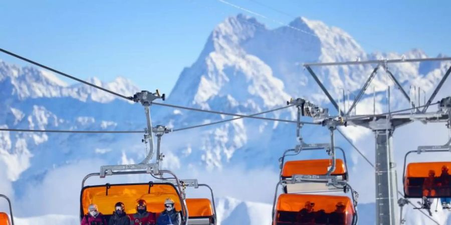 Mitten im Lockdown: Skifahrer im Skigebiet Ischgl in einem Sessellift. Foto: Karl-Josef Hildenbrand/dpa