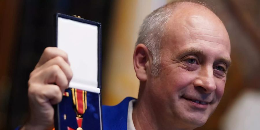 Der deutsch-französische Kabarettist und Satiriker Emmanuel Peterfalvi alias Alfons hält sein Verdienstkreuz am Bande nach der Verleihung im Rathaus hoch. Alfons erhielt die Auszeichnung für seine Verdienste für die Kultur und Toleranz und Humanität sowie sein Engagement für die Völkerverständigung. Foto: Marcus Brandt/dpa